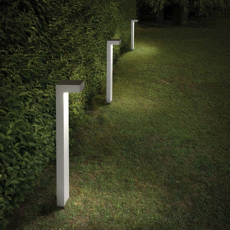 Stehleuchte Sirio Pt2 Gross Weiß in einem gepflegten Garten bei Nacht, ideal für elegante Außenbeleuchtung.