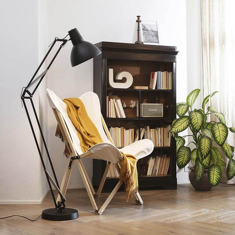 Wally Stehleuchte 160cm neben einem gemütlichen Sessel und Pflanzen in einem modernen Wohnraum.