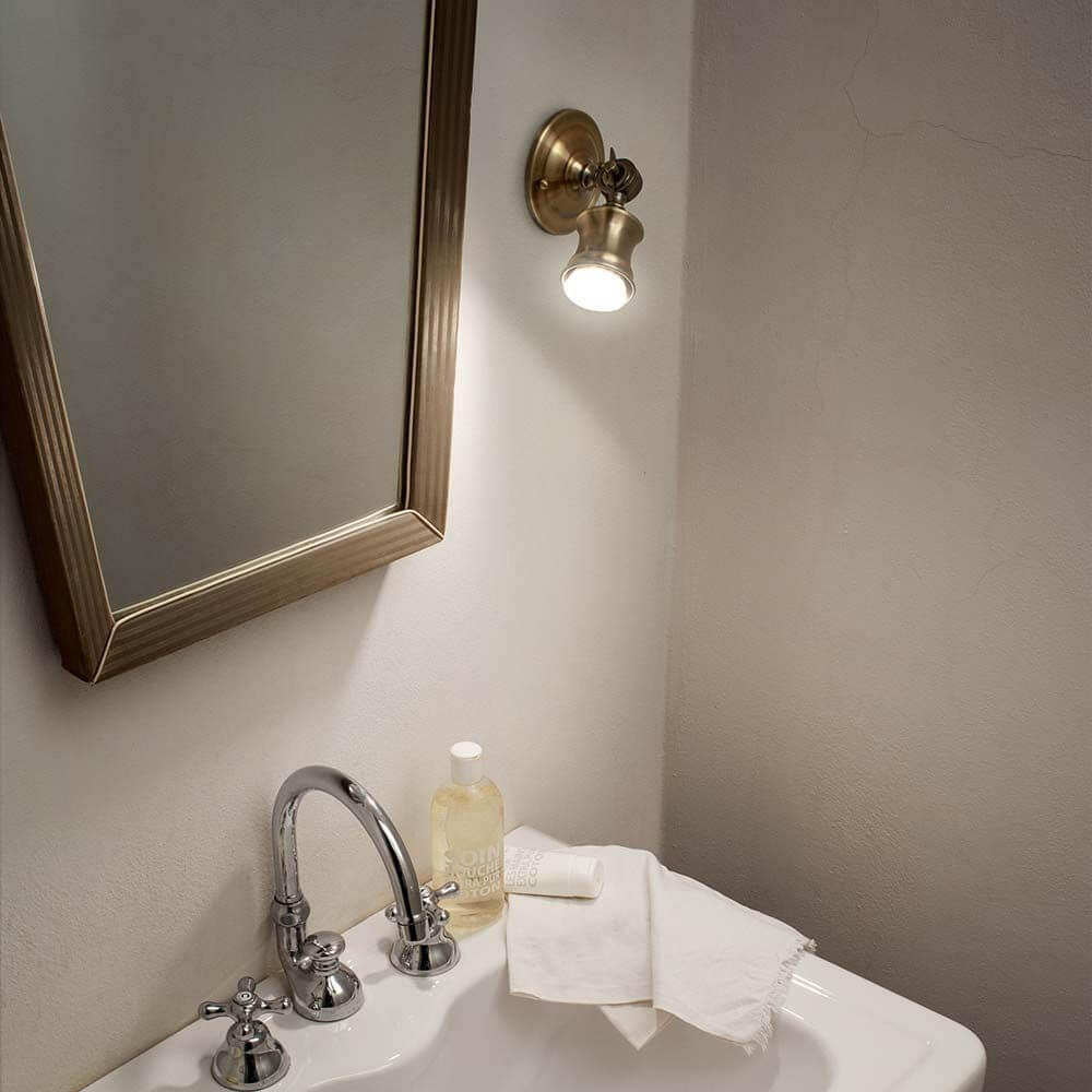 Wandlampe Barber Brüniert an einer Wand über einem Waschbecken mit Spiegel.