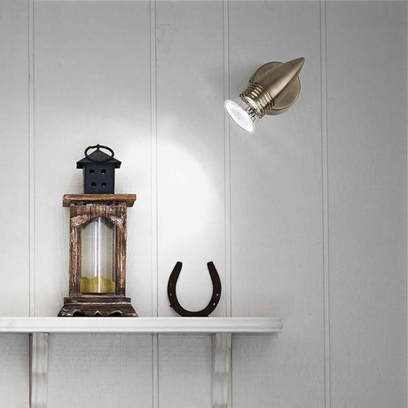 Wall light Alfa Ap1 Burnished on a wall above a shelf with a lantern and a horseshoe.