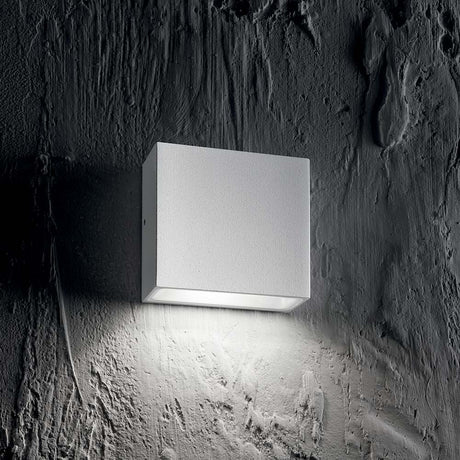 Wandleuchte Tetris-1 Ap1 Weiß an einer grauen Wand, modern und stilvoll, mit sanftem Licht.