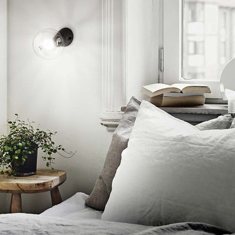 Wall light Winery Ap1 ceramic black in a cozy bedroom with plants and decorations.