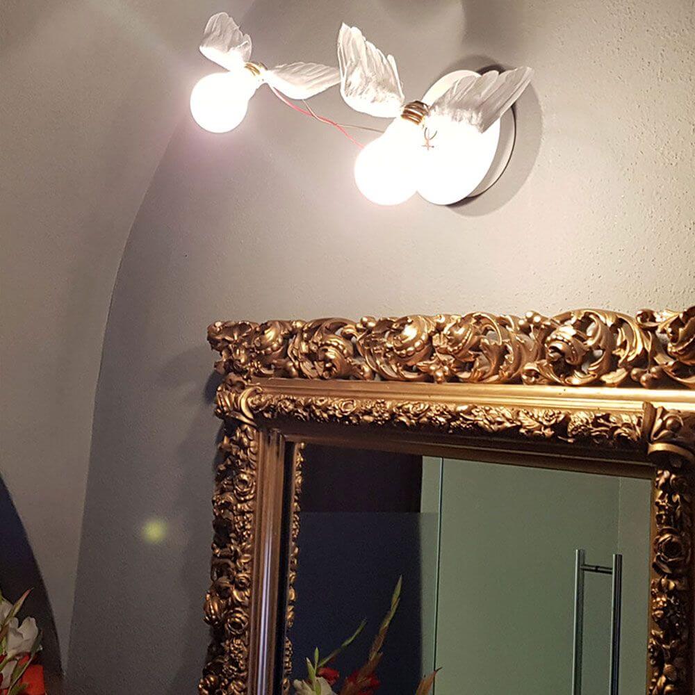 Ingo Maurer Lucellino Doppio LED Wand- und Deckenlampe in elegantem Raum mit goldenen Rahmen.