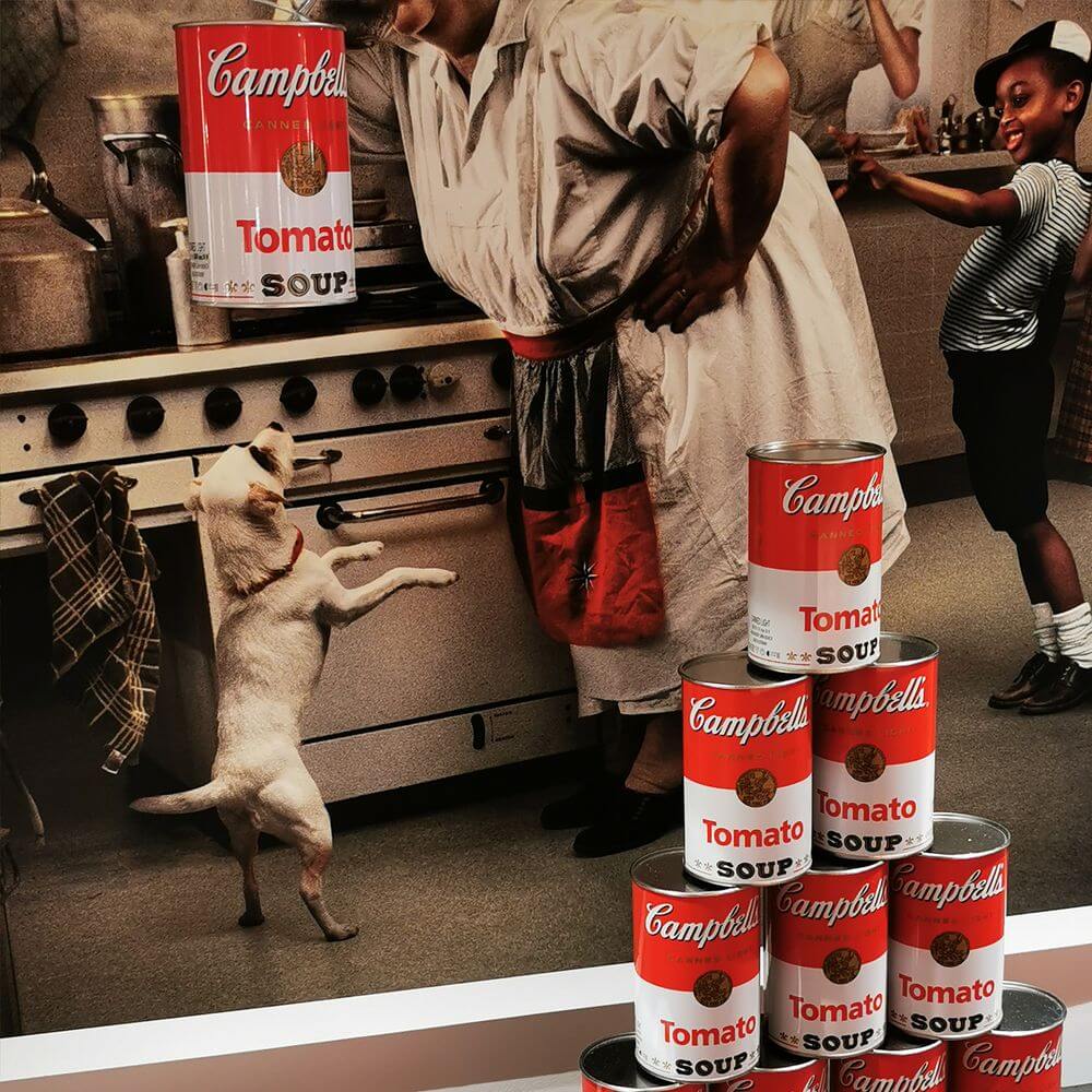 Ingo Maurer LED Wand- & Hängeleuchte Canned Light in einer modernen Küche mit Campbell's Tomato Soup Dosen.