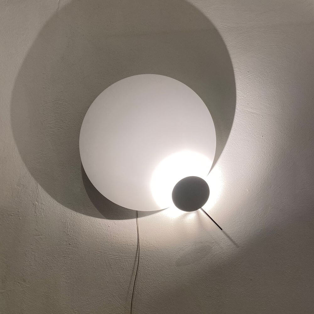 Ingo Maurer LED Wandlampe Eclipse Ellipse Ø 60cm mit besonderen Licht- und Schattenspielen an der Wand.