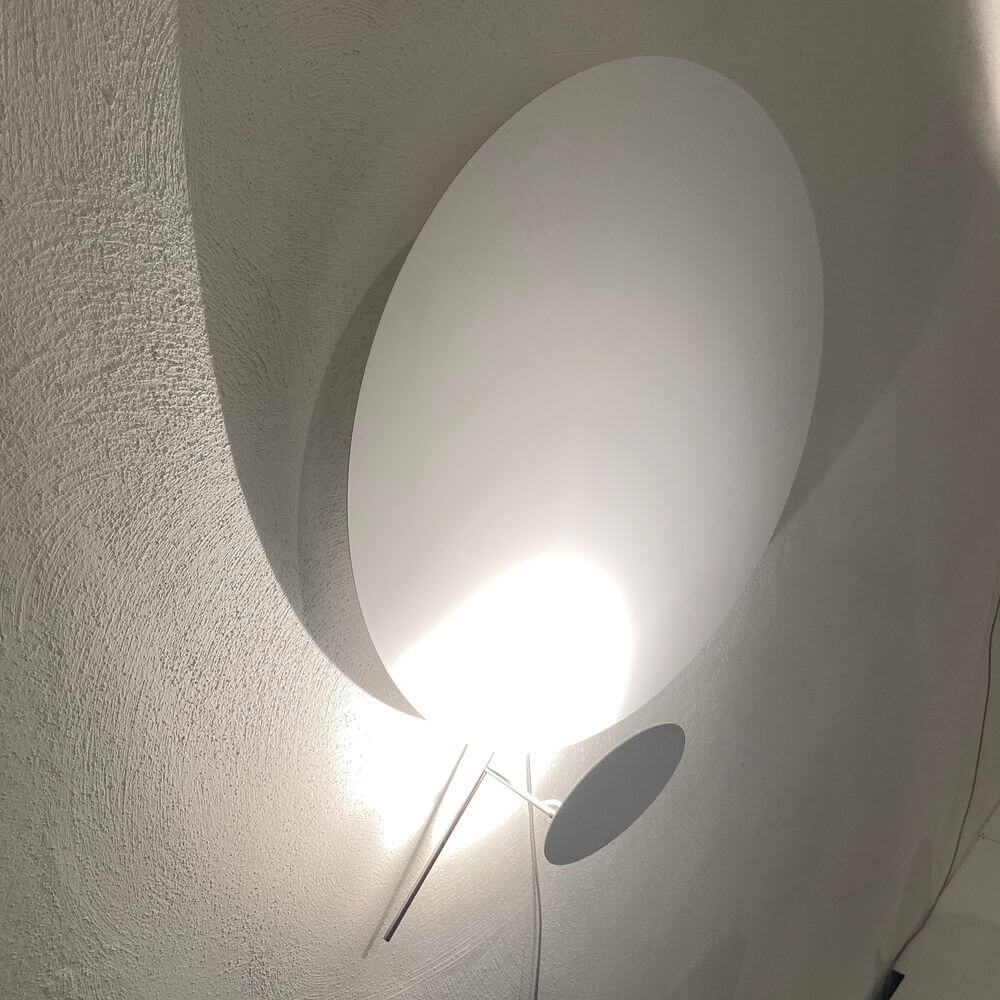 Ingo Maurer LED Wandlampe Eclipse Ellipse Ø 60cm an der Wand, erzeugt Licht und Schatten.