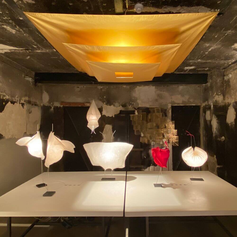 Ingo Maurer Stehleuchte Poul Poul Papierleuchte in einem Ausstellungsraum mit kreativen Lichtobjekten.