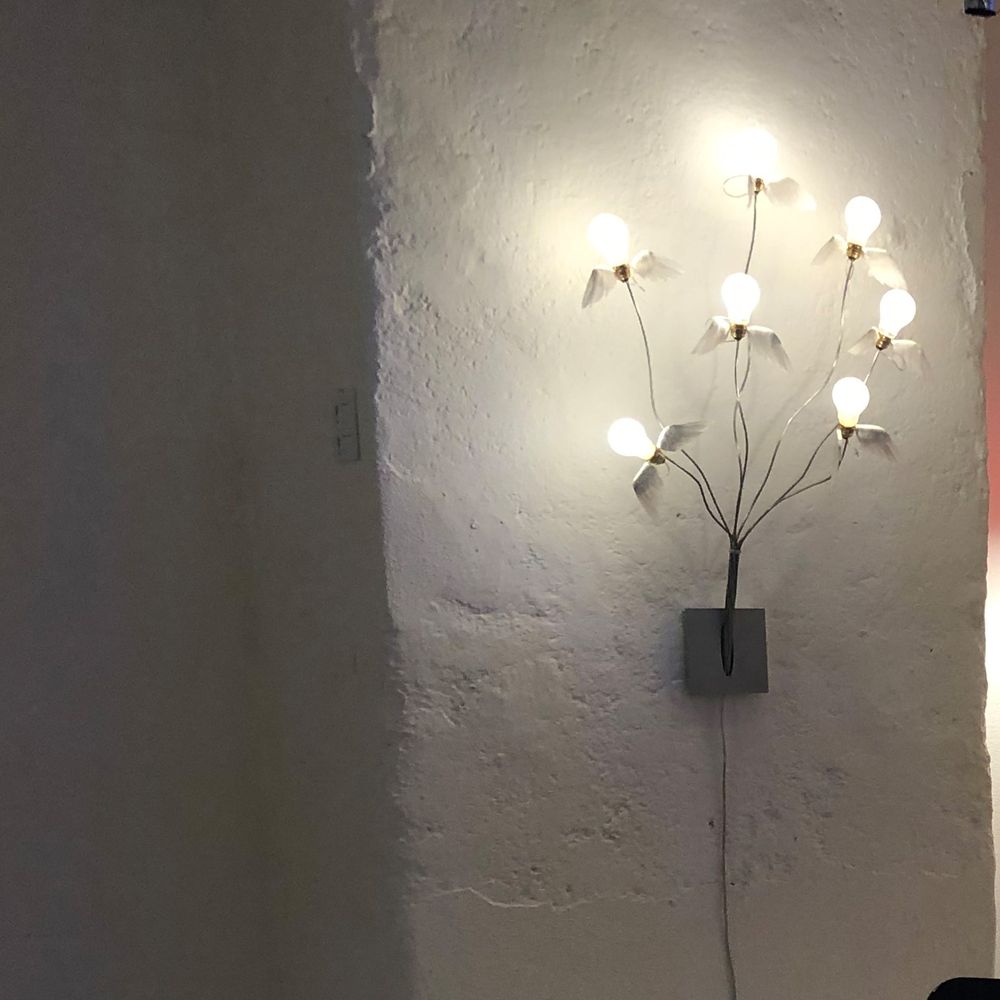 Wandleuchte Ingo Maurer Seven off the Wall mit sieben geflügelten Birnen auf Stäben aus verzinntem Kupfer.