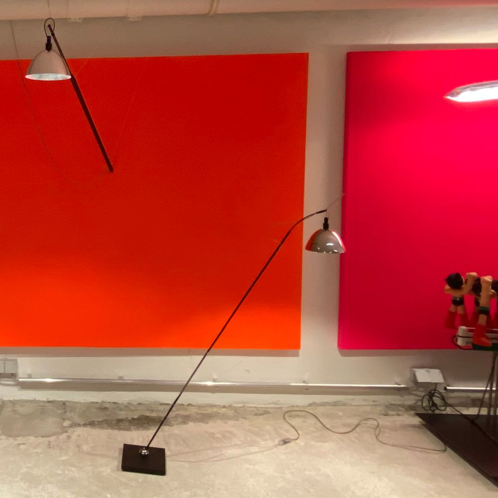 Ingo Maurer Max. Mover LED Lampe in einem modernen Raum mit leuchtenden orange und pinken Wänden.