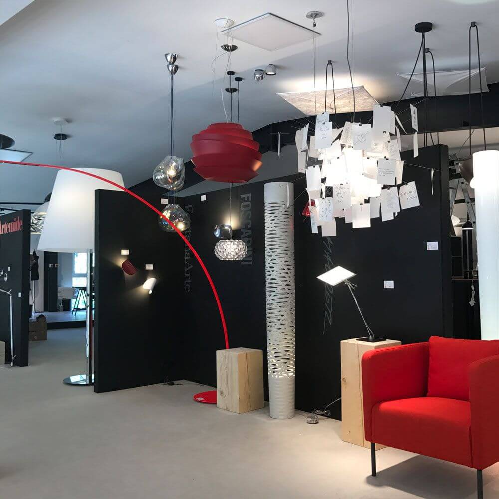 Moderne Innenraumgestaltung mit verschiedenen Lampen, darunter die Ingo Maurer Zettel'z 6 Hängelampe, stilvolles Ambiente.