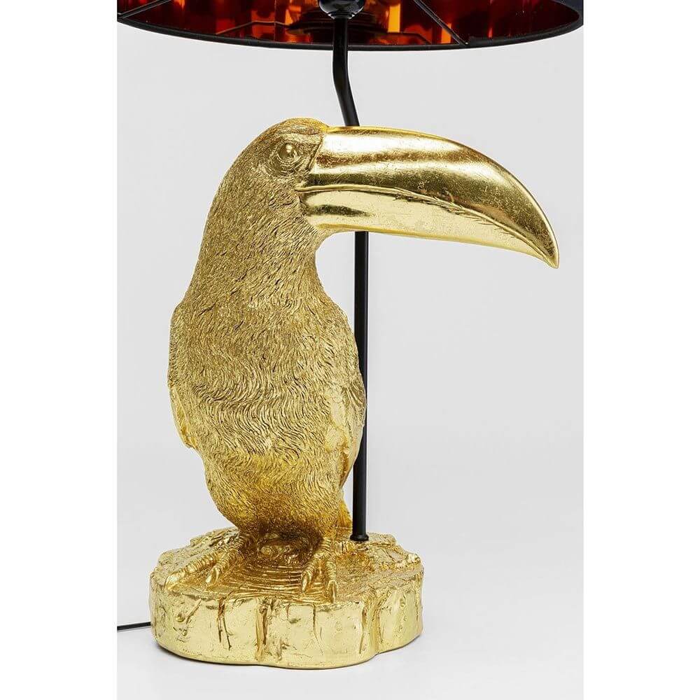 Tischleuchte Toucan Goldfarben mit goldfarbenem Tukansockel und schwarzem Lampenschirm.