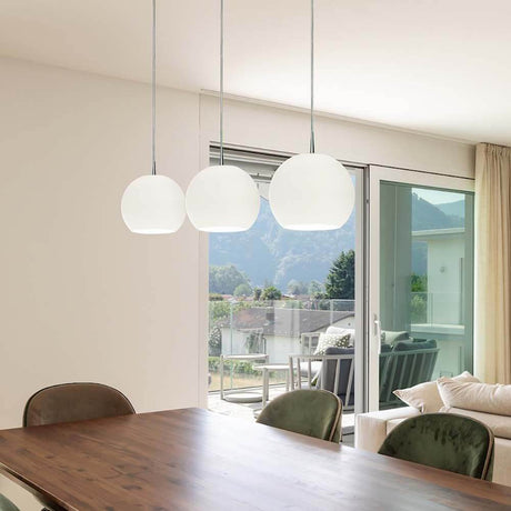 Casablanca Kabel-Pendellampe Ball 3-flammig hängt über einem Esstisch in modernem Interieur.