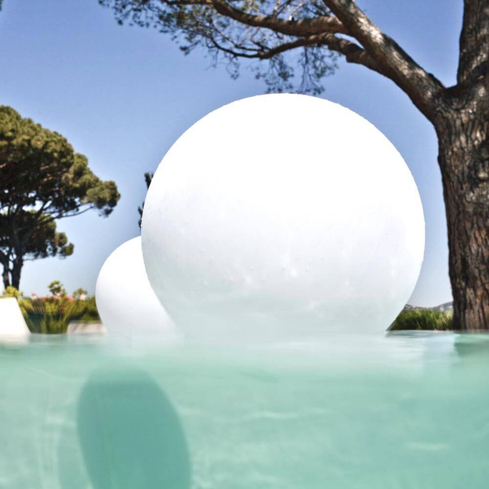 Lampe d'extérieur LED sans fil Pearl avec contrôle par application flottant dans la piscine entre les arbres, décoration lumineuse parfaite.