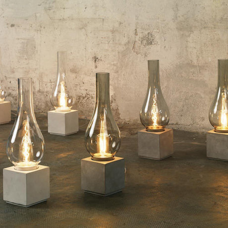Karman Amarcord Tischlampe in eleganter Design-Serie mit Glas und Betonfuß auf Boden.