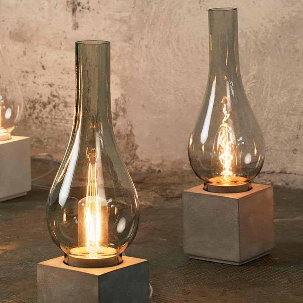 Karman Amarcord Tischlampe mit klarem Glas und modernem Betonsockel, elegantes Design für jeden Wohnbereich.