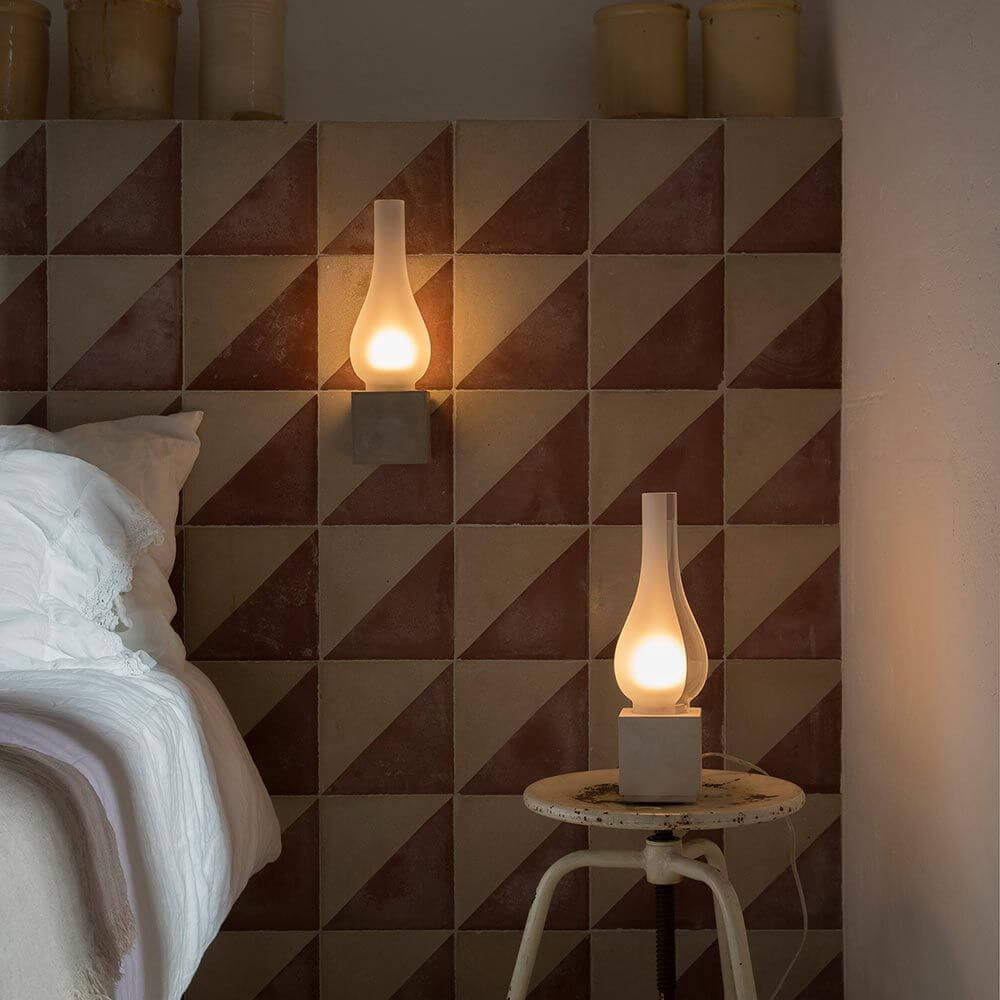 Karman Amarcord Wandleuchte an einer stilvollen Wand mit geometrischen Fliesen im Schlafzimmer.