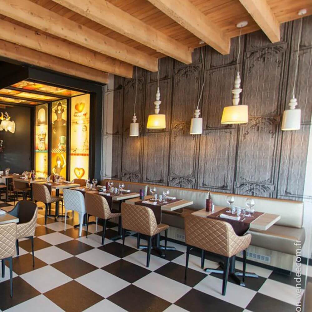 Innenansicht eines Restaurants mit eleganten Lampen und moderner Einrichtung im Schwarz-Weiß-Design.