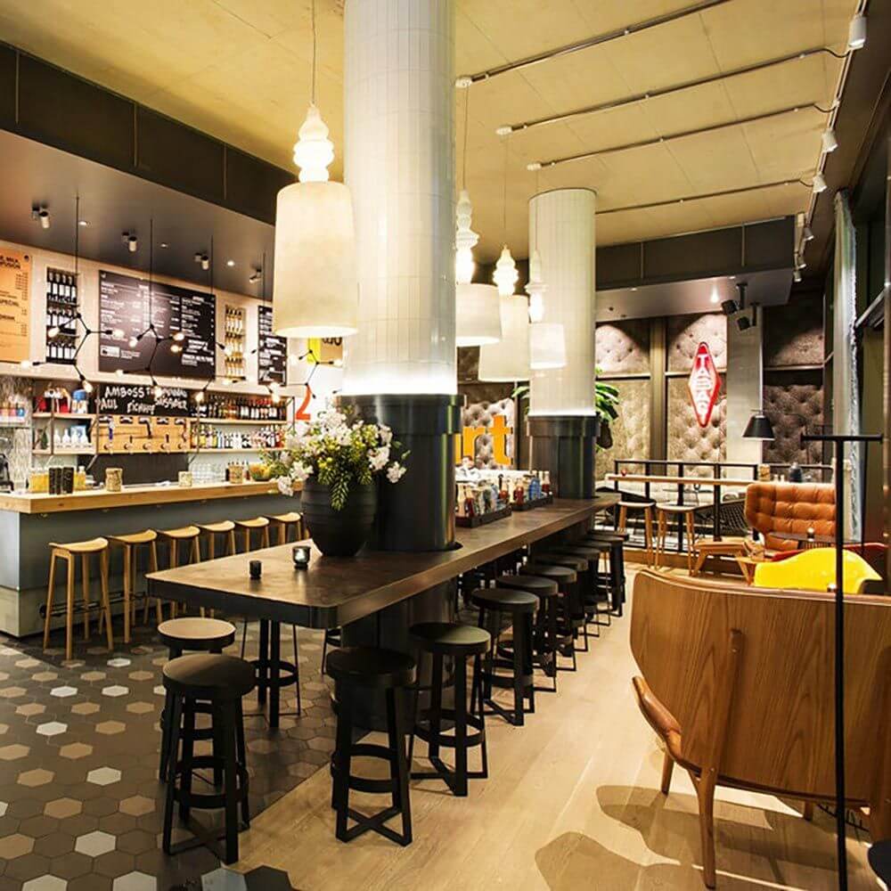 Moderne Bar mit Hell-Dunkel-Kontrasten, stilvollen Möbeln und eleganter Beleuchtung, ideal für gesellige Abende.