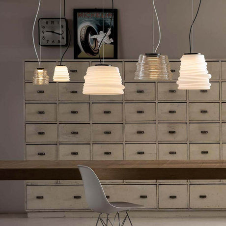 Karman Bibendum LED suspension en différentes hauteurs dans un plafond moderne au-dessus d’une table en rondins de bois.