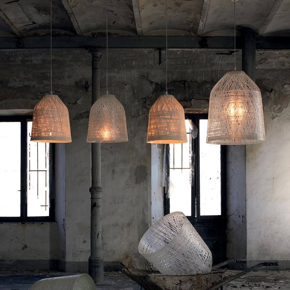 Karman Black Out Außen-Hängeleuchte IP65 in einem stilvollen Raum mit Korbgeflecht-Optik.