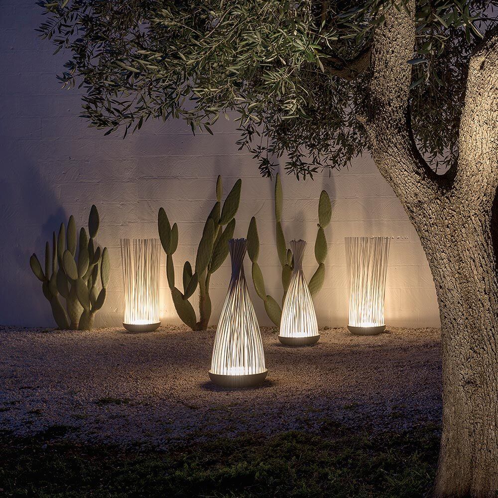 Karman Don't Touch LED Außen-Bodenleuchte in einem Garten, sanft beleuchtet, mit Schilfrohr-Optik.