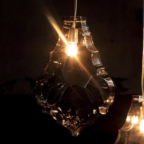 Karman Hängeleuchte 24 Karati aus eckigem Glas mit funkelndem Licht im Hintergrund.