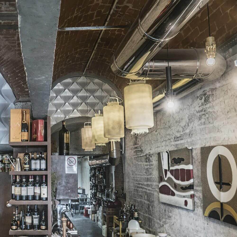 Karman Kimono Hängeleuchte im modernen Innenraum mit Bar und Weinregal.