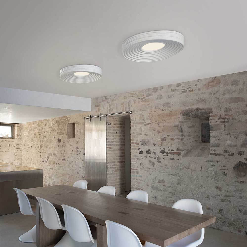 Karman LED-Deckenleuchte R.O.M.A. in modernem Raum, mit eleganten Wellenmustern und direkter Beleuchtung.
