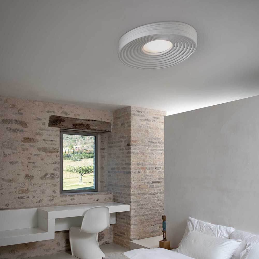 Karman LED-Deckenleuchte R.O.M.A. in modernem Schlafzimmer mit strukturierter Wand.
