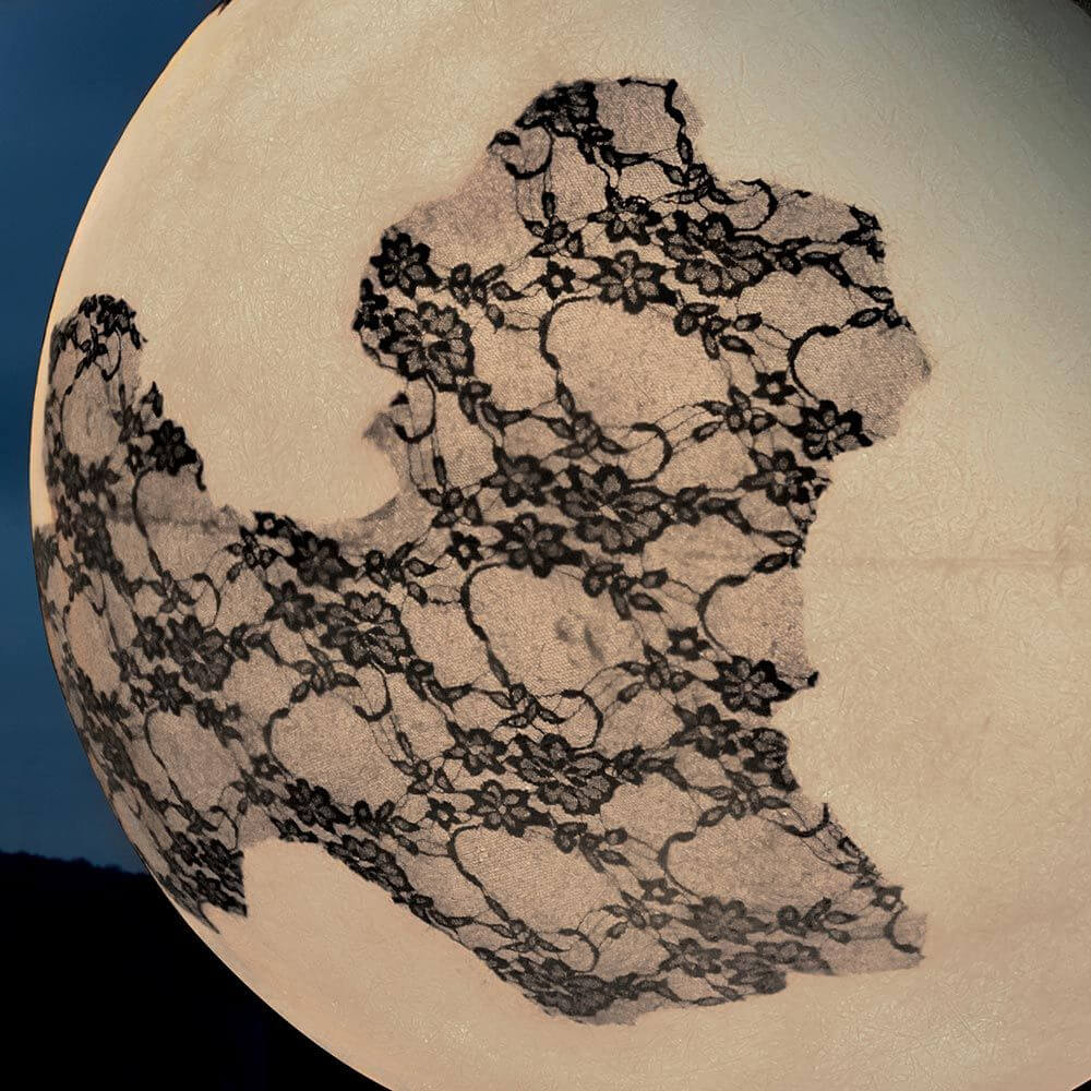 Karman Ulula LED-Bodenlampe Ø 75cm mit filigranem Spitzenmuster auf der Oberfläche, dieKontinente darstellt.