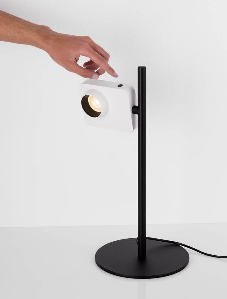 Kedros LED Tischleuchte 3000K mit Lampenfuß in Schwarz, Hand schaltet das Licht ein.