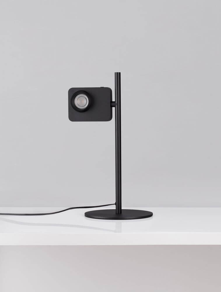 Kedros LED Tischleuchte 3000K mit Lampenfuß auf einem weißen Tisch, modernem Design in Schwarz.