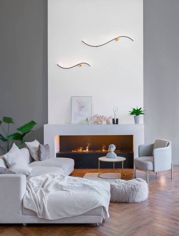 Kima LED Wandleuchte Geschwungen 3000K Schwarz, Gold im modernen Wohnzimmer über Kamin.