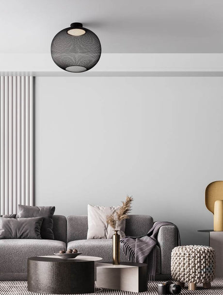Plafonnier Kinetic LED 3000K noir au-dessus d’un salon moderne avec canapé gris et décoration.