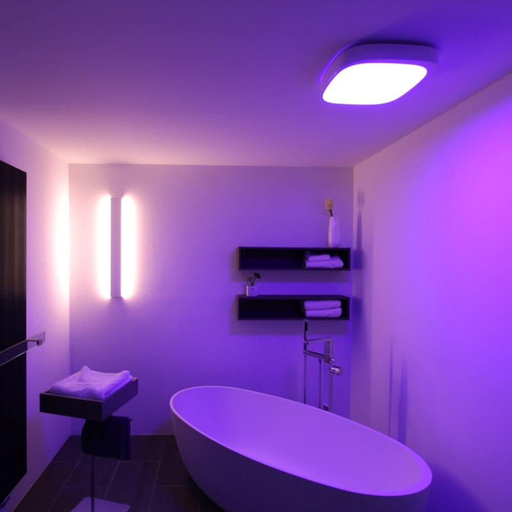 Sovt Campus LED Deckenlampe HCL RGBW Tageslicht NeoLink DALI in modernem Badezimmer mit lila Beleuchtung.
