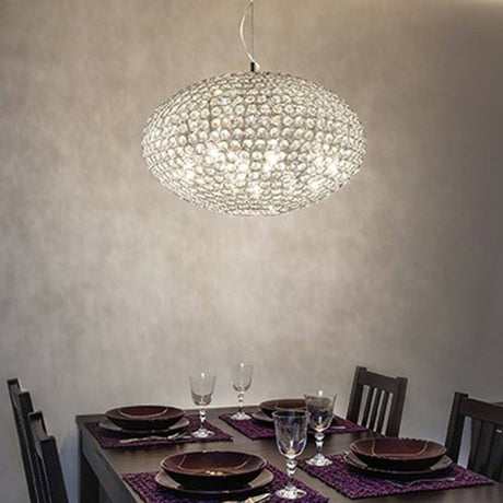 Kristall-Pendelleuchte Orion SP8 Ø50cm Chrom über einem eleganten Esstisch mit gedecktem Tisch.
