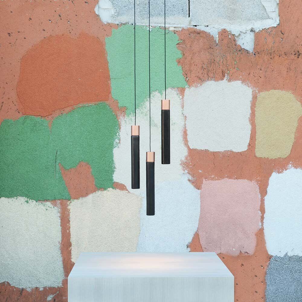 Kundalini Keramik LED Pendelleuchte Minimal Dimmbar an einer farbenfrohen Wand.