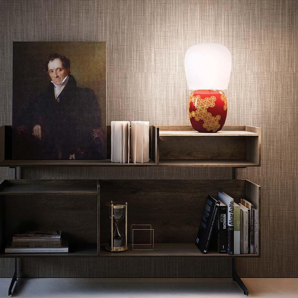 Kundalini Keramik Tischlampe Hive 47cm Dimmbar auf einem Bücherregal mit Kunst und Büchern.