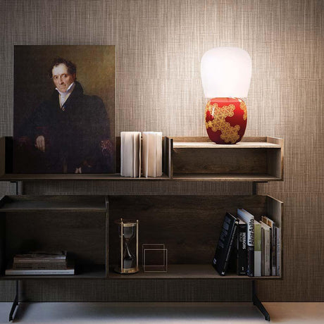 Kundalini Keramik Tischlampe Hive 47cm Dimmbar auf einem Bücherregal mit Kunst und Büchern.