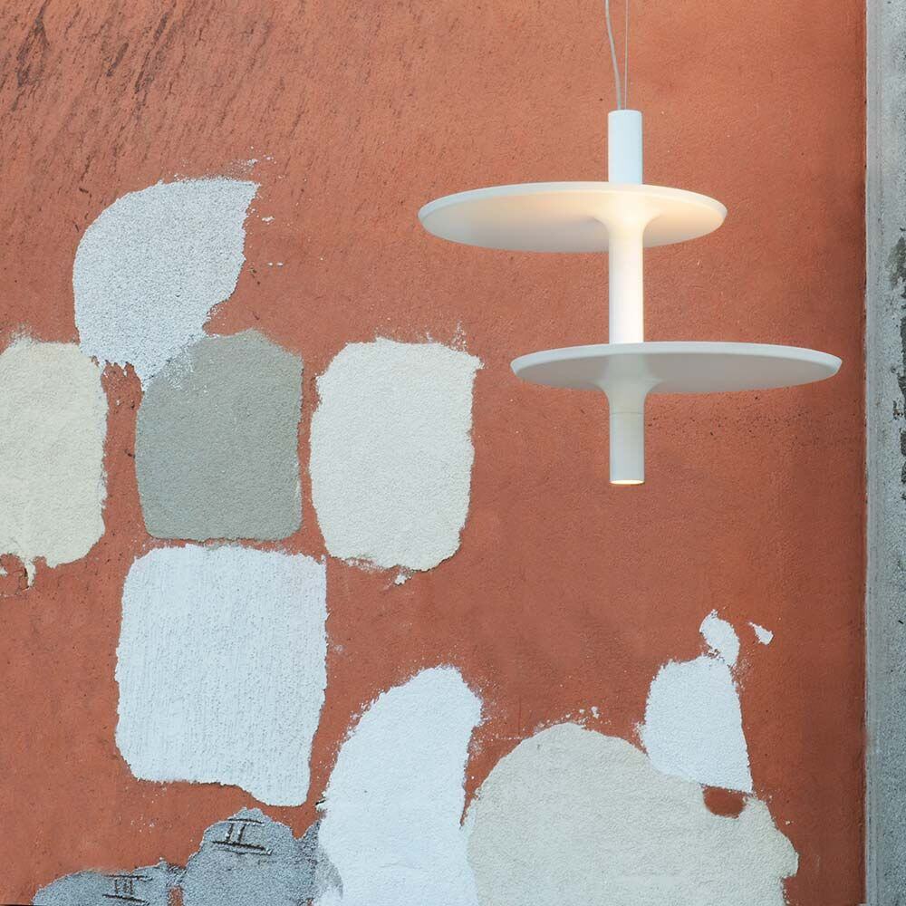 Kundalini LED Pendelleuchte Victoria 55cm Dimmbar über einem farbigen, strukturierten Wandhintergrund.