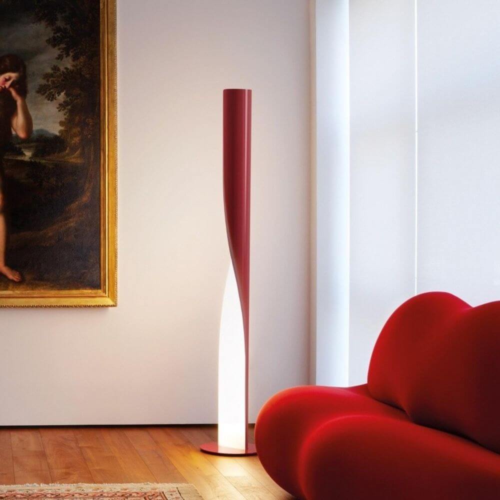 Kundalini Stehleuchte Evita 190cm Dimmbar steht in modernem Raum mit rotem Sofa und Kunstwerk.