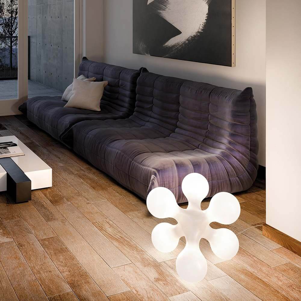Kundalini Tisch- & Bodenlampe Atomium mit organischer Form im modernen Wohnzimmer, strahlt sanftes Licht aus.
