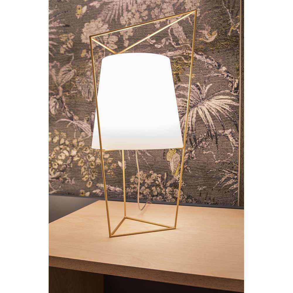 Kundalini Tischlampe Tatu 69cm mit Dimmer auf einem Tisch, mit geometrischem Design und goldener Struktur.