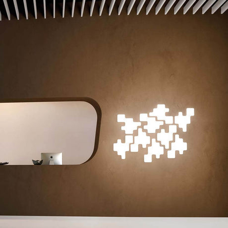 Kundalini Wand- & Deckenlampe Pixel Dimmbar an einer Wand mit kreativem Design und sanftem Licht.