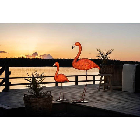LED Acryl Flamingo groß 96 bernsteinfarbene Dioden IP44 auf einer Terrasse bei Sonnenuntergang.
