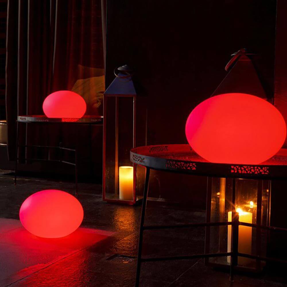 LED Akkulampe Flatball L mit App-Steuerung leuchtet rot und dekoriert moderne Innenräume.
