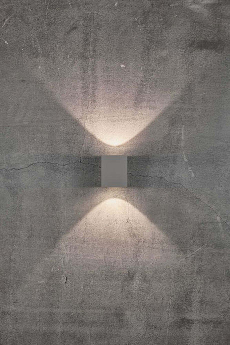 LED Außen-Wandlampe Canto Kubi 2 IP44 Grau an einer Betonwand mit Lichtstrahlen oben und unten.