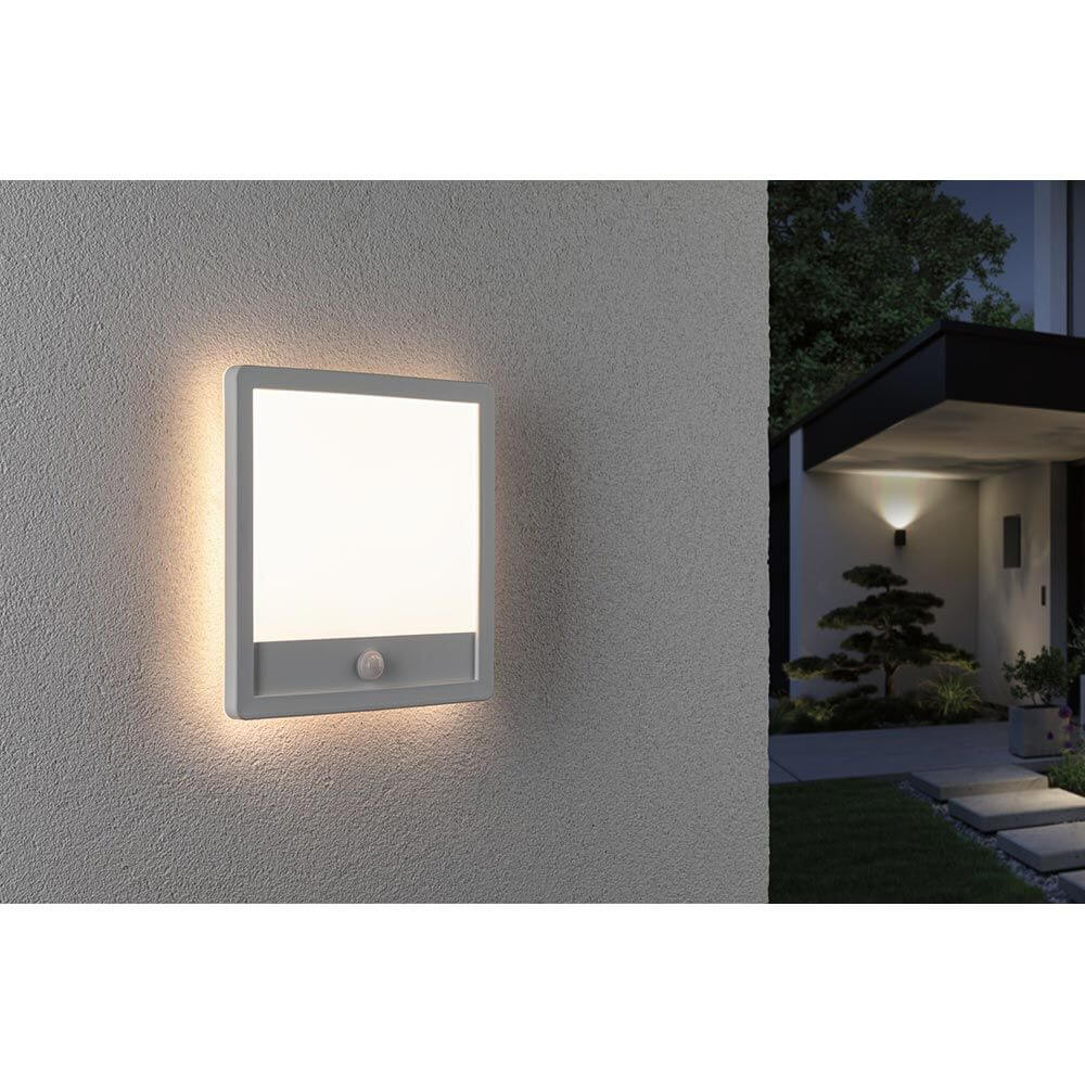 LED Außen Wandleuchte Lamina Bewegungssensor Weiß an einer Wand montiert im Außenbereich.