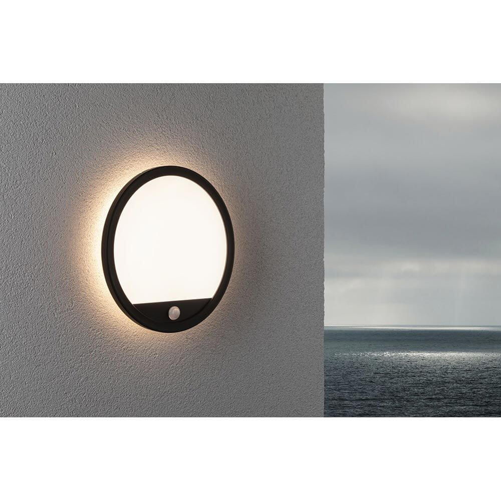 LED Außen Wand- & Deckenpanel Lamina Bewegungssensor an Wand mit schwarzem Rahmen und sanftem Licht.