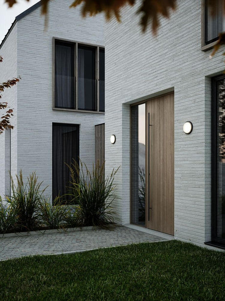 LED Outdoor wall light Cuba Outdoor Energy Round IP54 on a modern facade with wood and glass elements.